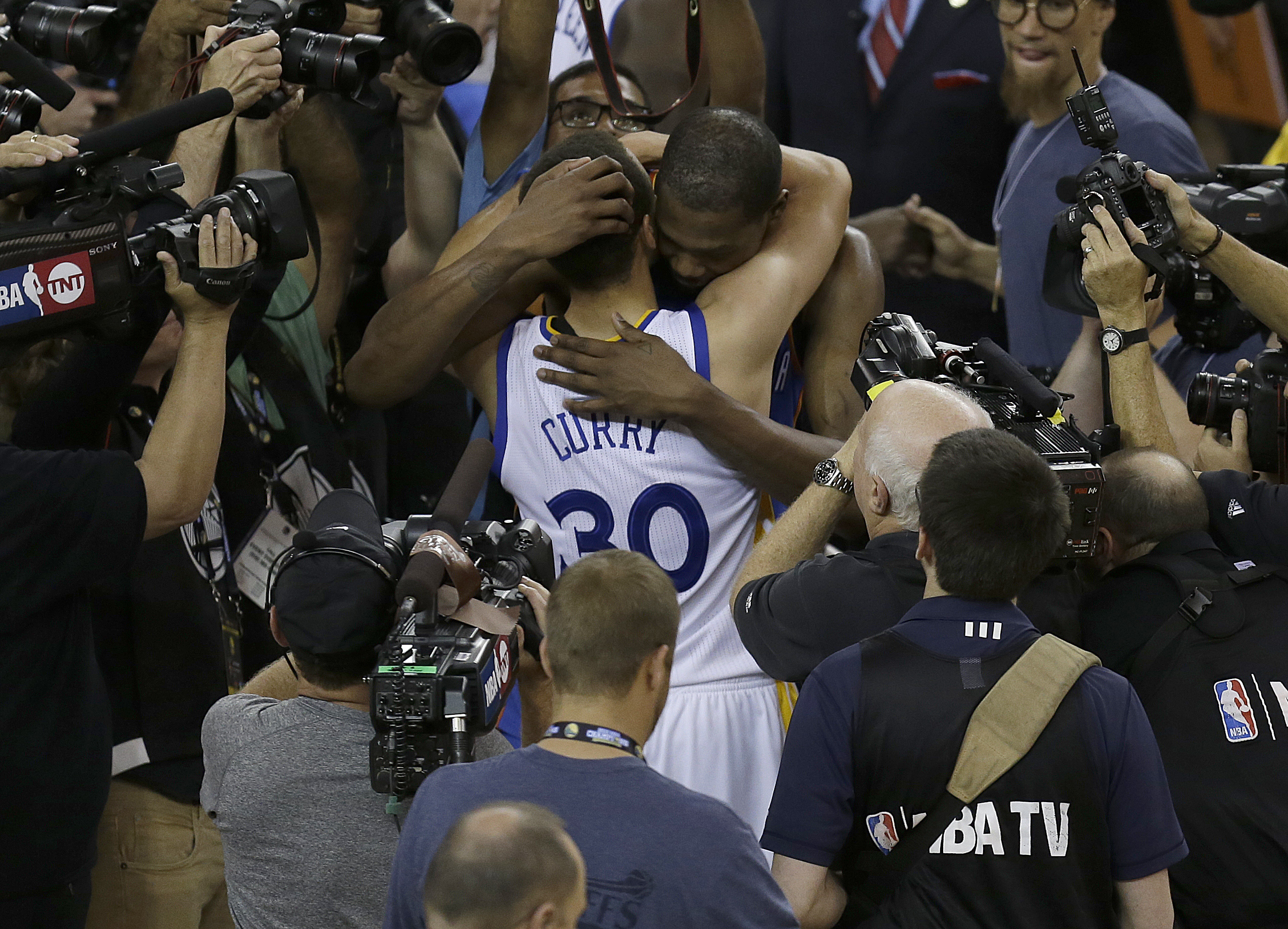 Golden State Warriors guard Stephen Curry (30) hugs Oklahoma City Thunder forward Kevin Durant after Game 7 of the NBA basketball Western Conference finals in Oakland, Calif., Monday, May 30, 2016. The Warriors won 96-88. (AP Photo/Ben Margot)
